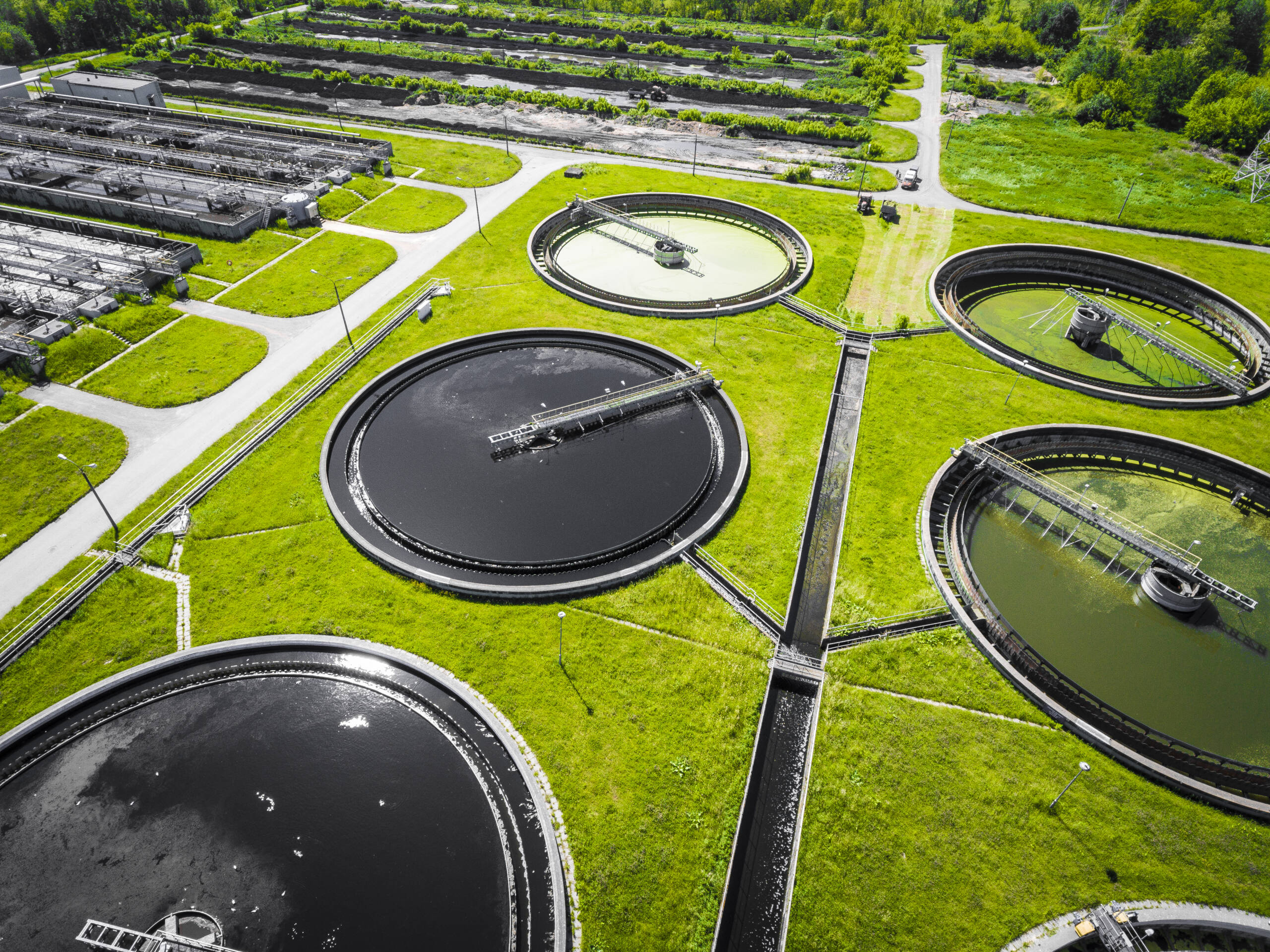 Sewage farm. Static aerial photo looking down onto the clarifyin Sewage farm. Static aerial photo looking down onto the clarifying tanks and green grass. Geometric background texture.
